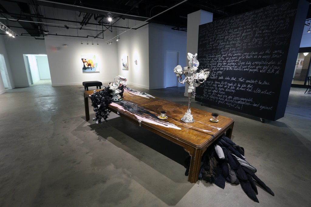 The black wall features text from the performance piece by David Antonio Cruz, greenhowiwantyou, green. Installation of a brokenn table with paint, paper with resin, sculpture and costumes pieces from past performances. The black wall features text from the performance piece by David Antonio Cruz, greenhowiwantyou, green. Installation of a brokenn table with paint, paper with resin, sculpture and costumes pieces from past performances.