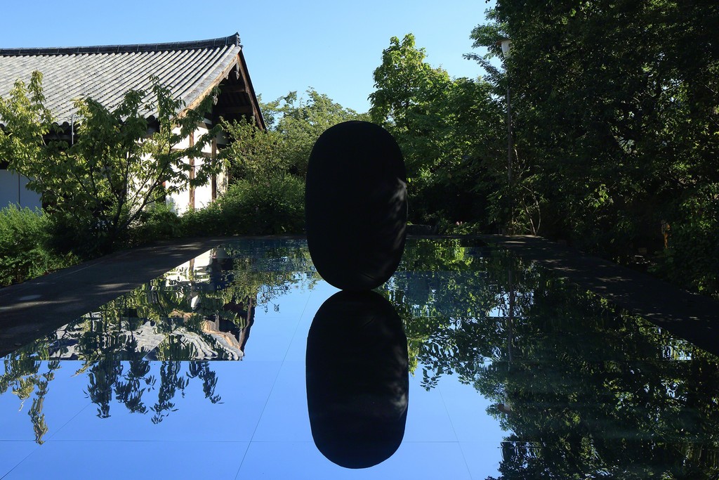 Kimsooja, Deductive Object, 2016, black casted aluminum on mirror, 1.83m x 1.1m (sculpture), 8m x 5m (mirror). Gangoji Temple, Nara, Japan. Commissioned by Culture City of East Asia 2016, Nara. Photo by Keizo Kioku. Courtesy of Art Front Gallery Co., Ltd. and Kimsooja Studio. Kimsooja, Deductive Object, 2016, black casted aluminum on mirror, 1.83m x 1.1m (sculpture), 8m x 5m (mirror). Gangoji Temple, Nara, Japan. Commissioned by Culture City of East Asia 2016, Nara. Photo by Keizo Kioku. Courtesy of Art Front Gallery Co., Ltd. and Kimsooja Studio.