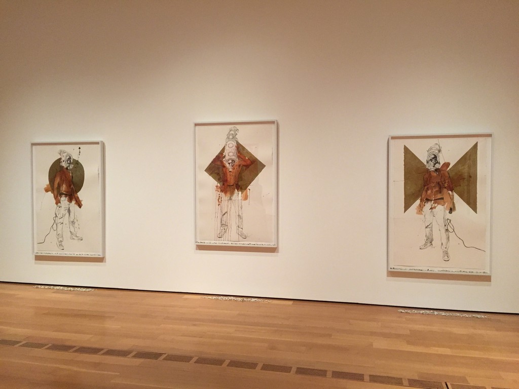 "The Messenger I, II, III" installation view, 2014, acrylic and graphite on paper with cowries, 60 x 40 inches (each) "The Messenger I, II, III" installation view, 2014, acrylic and graphite on paper with cowries, 60 x 40 inches (each)
