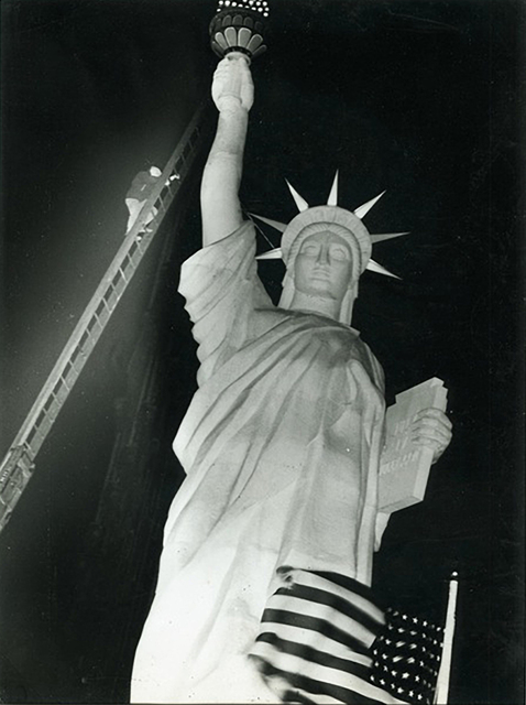 Weegee, ‘Man climbs 85-foot ladder to secure torch on the plastic Statue of Liberty erected at Times Square for the Sixth War Loan Drive, New York’, 1944, Elizabeth Houston Gallery