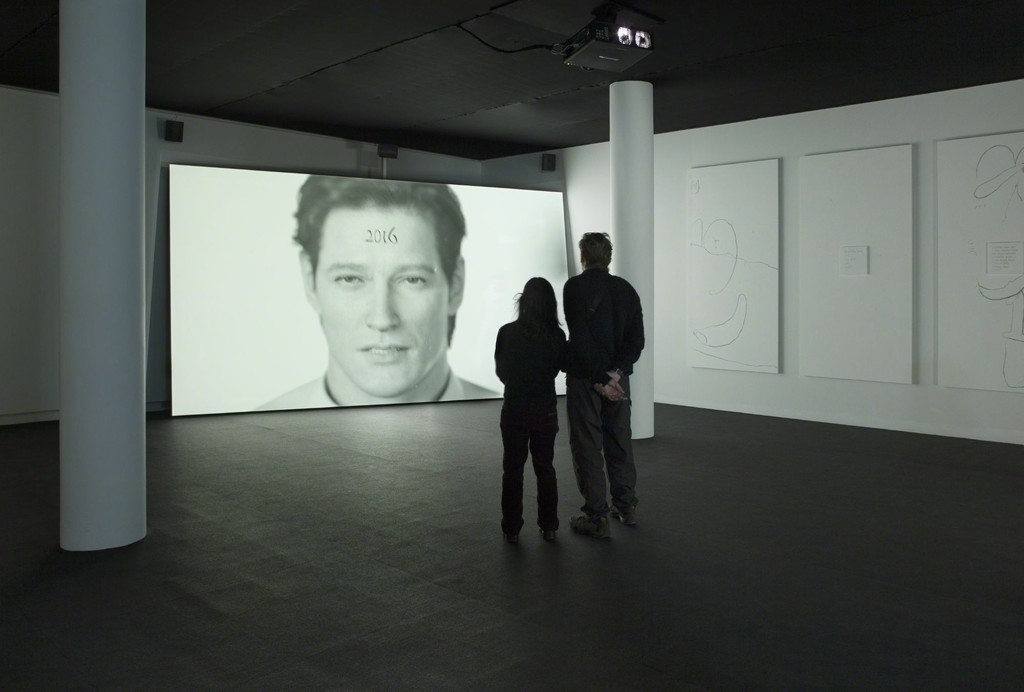 Installation shot of Ed Atkins' Happy Birthday!!!, 2015. Installation. 16:9 HD projection with 5.1. surround sound, two silent 16:9 films, 10 paintings on board with six perspex text panels. Photo from the exhibition 'Fire under Snow: New film and video works at Louisiana', 27.1.-8.5.2016, Louisiana Museum of Modern Art. Installation shot of Ed Atkins' Happy Birthday!!!, 2015. Installation. 16:9 HD projection with 5.1. surround sound, two silent 16:9 films, 10 paintings on board with six perspex text panels. Photo from the exhibition 'Fire under Snow: New film and video works at Louisiana', 27.1.-8.5.2016, Louisiana Museum of Modern Art.