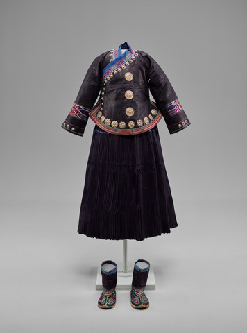 Woman’s Jacket, Skirt, and Boots, China, Yunnan Province, Wenxuan Prefecture, Zhuang, mid-20th century. Indigo-dyed cotton coated with egg white or animal blood and beaten, with silk embroidery, metal foil, and silver buttons and ornaments. Yale University Art Gallery, Ann B. Goodman Collection, Gift of Ann B. Goodman. Woman’s Jacket, Skirt, and Boots, China, Yunnan Province, Wenxuan Prefecture, Zhuang, mid-20th century. Indigo-dyed cotton coated with egg white or animal blood and beaten, with silk embroidery, metal foil, and silver buttons and ornaments. Yale University Art Gallery, Ann B. Goodman Collection, Gift of Ann B. Goodman.