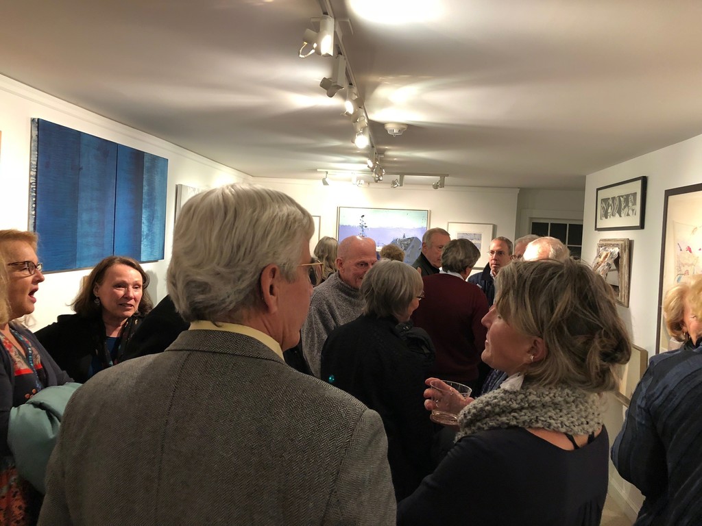 A crowd of patrons and friends view the art. A crowd of patrons and friends view the art.