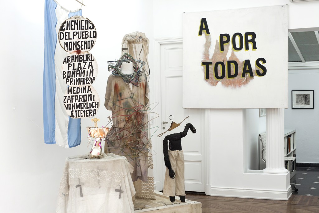 Exhibition view. On Front, Batato Barea's installation with props from his 1986 performance "Los Perros Comen Huesos", on the back, Gustavo Marrone's "A POR TODAS". Far on the back: Antonio Berni. Exhibition view. On Front, Batato Barea's installation with props from his 1986 performance "Los Perros Comen Huesos", on the back, Gustavo Marrone's "A POR TODAS". Far on the back: Antonio Berni.