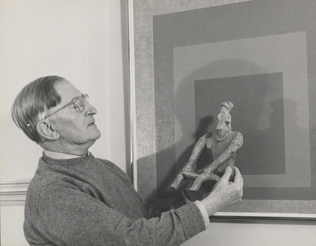 Lee Boltin, Untitled (Josef Albers Holding West Mexican Figure in front of Homage to the Square: Auriferous), 1958. Gelatin silver print. The Josef and Anni Albers Foundation, Bethany, Conn., 1976.28.923. © Lee Boltin. Photo courtesy the Josef and Anni Albers Foundation Lee Boltin, Untitled (Josef Albers Holding West Mexican Figure in front of Homage to the Square: Auriferous), 1958. Gelatin silver print. The Josef and Anni Albers Foundation, Bethany, Conn., 1976.28.923. © Lee Boltin. Photo courtesy the Josef and Anni Albers Foundation