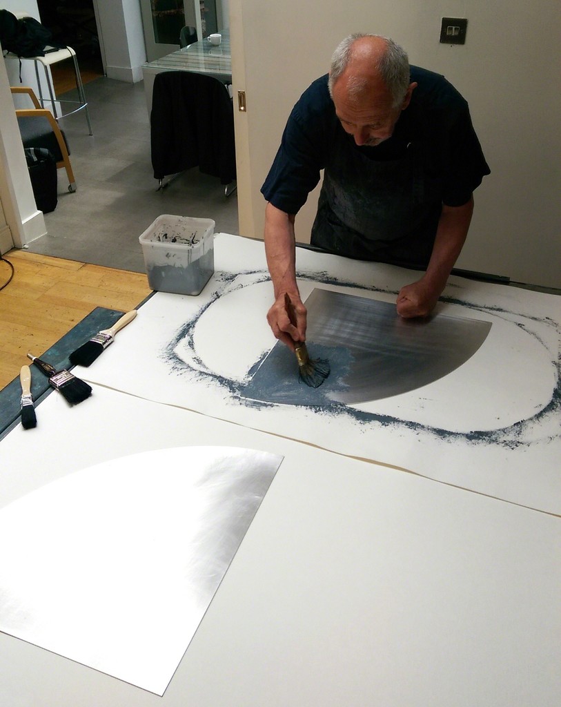 Painting carborundum on to shaped aluminium plates. Painting carborundum on to shaped aluminium plates.