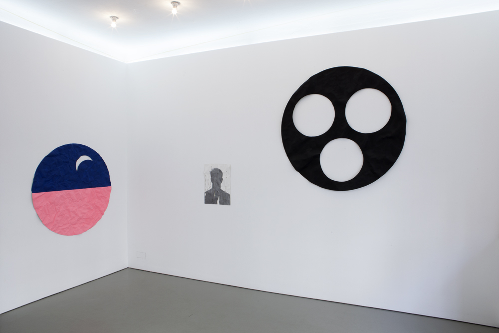 View of the exhibition 'DEAD FLAT' by Gil Shachar with three wall objects. The middle object is a portrait of a shadow of the artist himself in graphite on a epoxy cast of a wrinkled paper; photo: Lukas Heibges View of the exhibition 'DEAD FLAT' by Gil Shachar with three wall objects. The middle object is a portrait of a shadow of the artist himself in graphite on a epoxy cast of a wrinkled paper; photo: Lukas Heibges