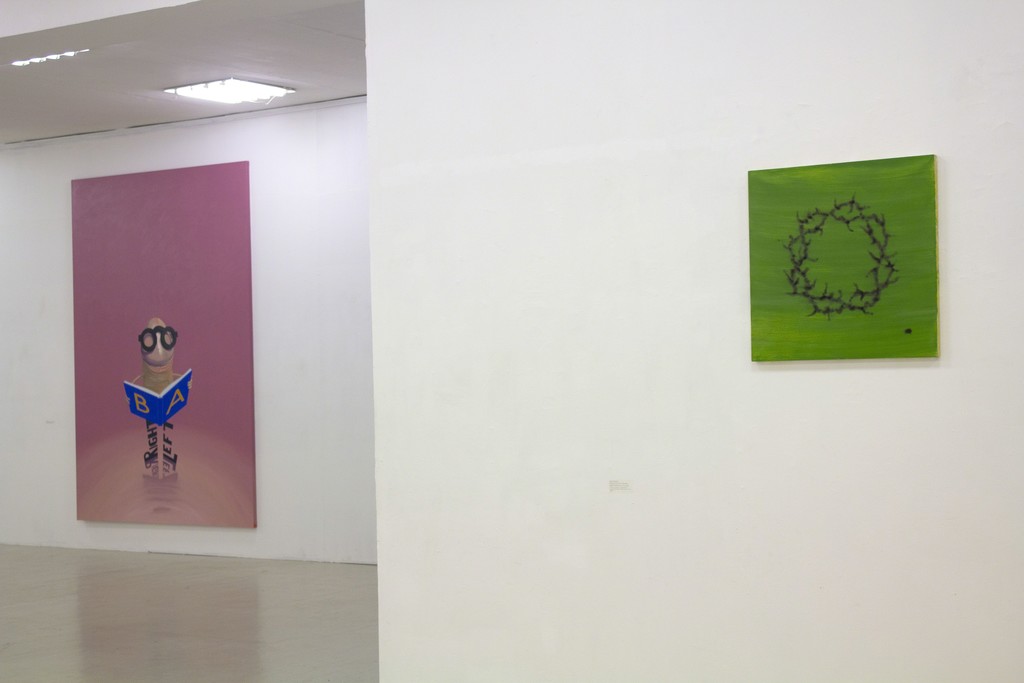 Fragment of exhibition "Družba".
On the left: Kaido Ole, "Freak with Book". 2014. Oil and acrylic on canvas, 280 x 190 cm.
On the right:
Jonas Gasiūnas, „Wreath Burnt on the Grass“. 2018. Oil and charcoal (from candle smoke) on canvas, 100 x 95 cm. Fragment of exhibition "Družba".
On the left: Kaido Ole, "Freak with Book". 2014. Oil and acrylic on canvas, 280 x 190 cm.
On the right:
Jonas Gasiūnas, „Wreath Burnt on the Grass“. 2018. Oil and charcoal (from candle smoke) on canvas, 100 x 95 cm.