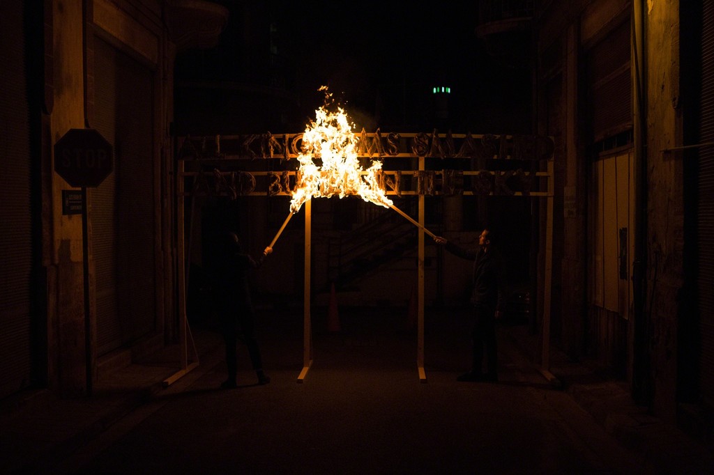 The fire poem was set alight with the Nicosia buffer zone as a backdrop. Photography: Antonis Minas The fire poem was set alight with the Nicosia buffer zone as a backdrop. Photography: Antonis Minas