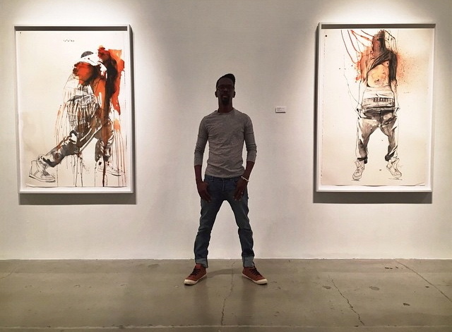 Artist Fahamu Pecou (standing) "Teth'rd" (left) and "Lifted" (right) "GRAV-I-TY" installation at MOCAGA Artist Fahamu Pecou (standing) "Teth'rd" (left) and "Lifted" (right) "GRAV-I-TY" installation at MOCAGA