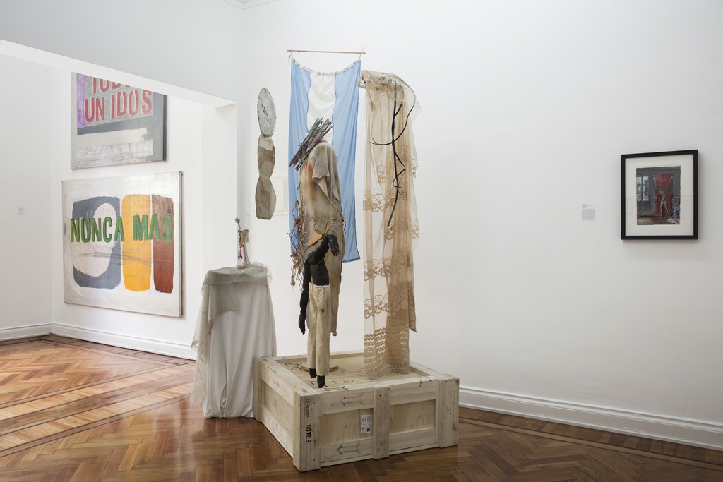 Exhibition View. Left, Gustavo Marrone, center, side view of Batato Barea's installation, right, Antonio Berni's "Cristo en el departamento" ca-1979-1981. Exhibition View. Left, Gustavo Marrone, center, side view of Batato Barea's installation, right, Antonio Berni's "Cristo en el departamento" ca-1979-1981.
