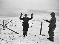 A US soldier with a German prisoner of war during the Battle of the Bulge. Near Bastogne. Belgium