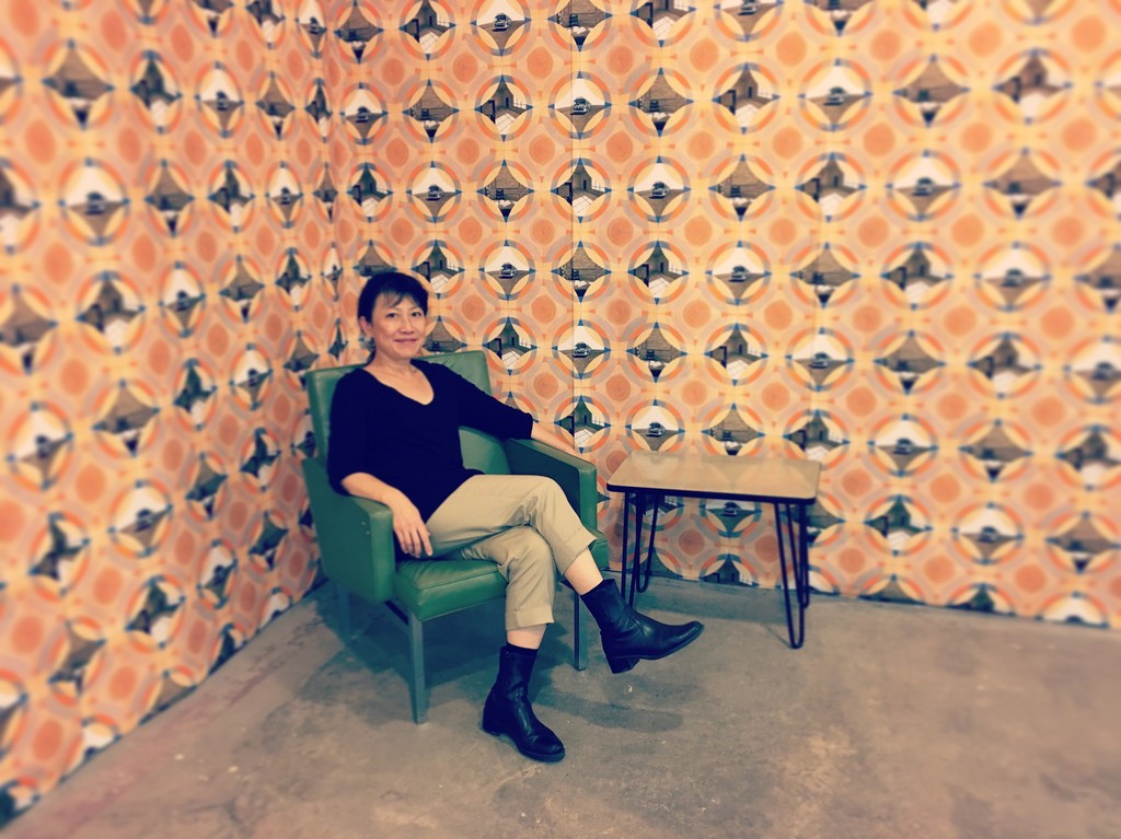 As part of the exhibition, "Prototype 1977" has been mocked up as actual wallpaper, complete with 1970s era furniture. Pictured here is the artist, Millie Chen. As part of the exhibition, "Prototype 1977" has been mocked up as actual wallpaper, complete with 1970s era furniture. Pictured here is the artist, Millie Chen.