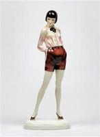 Louise Brooks as a young lady in a bob, standing in shorts on a rounded rectangular base