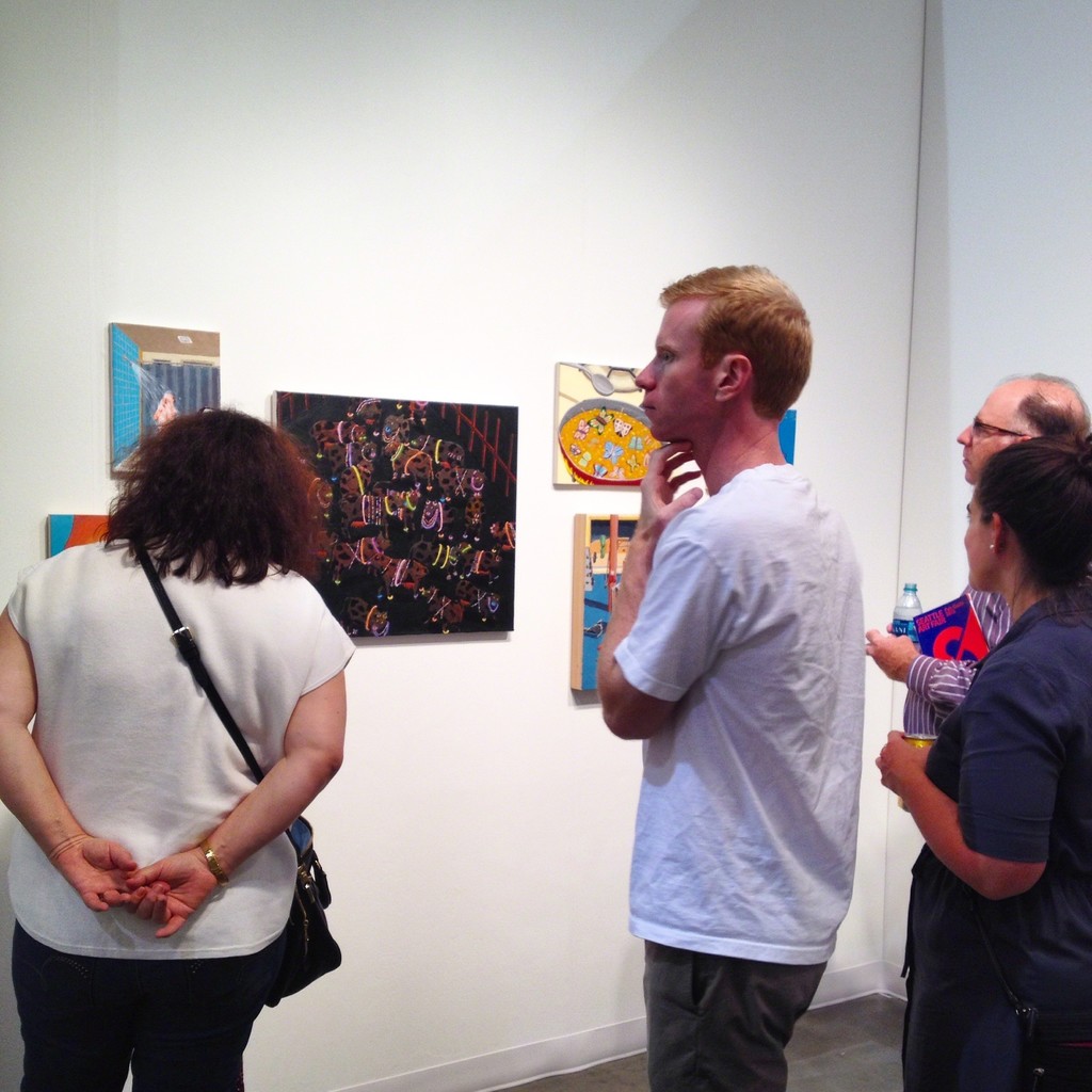 Art fair attendees take in paintings by Ralph Pugay during the Seattle Art Fair. Art fair attendees take in paintings by Ralph Pugay during the Seattle Art Fair.
