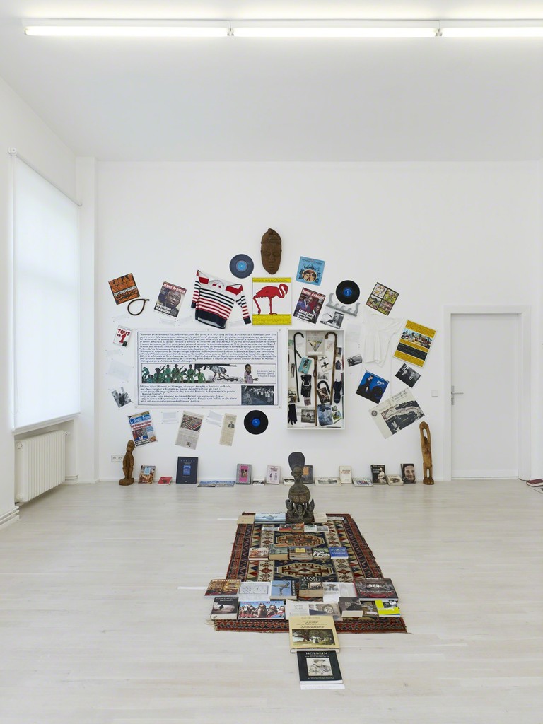 Georges Adéagbo „Les artistes et l‘écriture“..!, 2014, Mixed Media, wall 1: 320 (h) x 430 (w) x 22 (d) cm, wall 2: 310 (h) x 610 (w) x 19 (d) cm, wall 3: 290 (h) x 440 (w) x 22 (d) cm, floor: 285 x 140 x 64 cm, Installation view of „Les artistes et l‘écriture“..! at Gallery Wien Lukatsch, Berlin 2014, Courtesy: Gallery Wien Lukatsch, Berlin, Photos: Nick Ash Georges Adéagbo „Les artistes et l‘écriture“..!, 2014, Mixed Media, wall 1: 320 (h) x 430 (w) x 22 (d) cm, wall 2: 310 (h) x 610 (w) x 19 (d) cm, wall 3: 290 (h) x 440 (w) x 22 (d) cm, floor: 285 x 140 x 64 cm, Installation view of „Les artistes et l‘écriture“..! at Gallery Wien Lukatsch, Berlin 2014, Courtesy: Gallery Wien Lukatsch, Berlin, Photos: Nick Ash