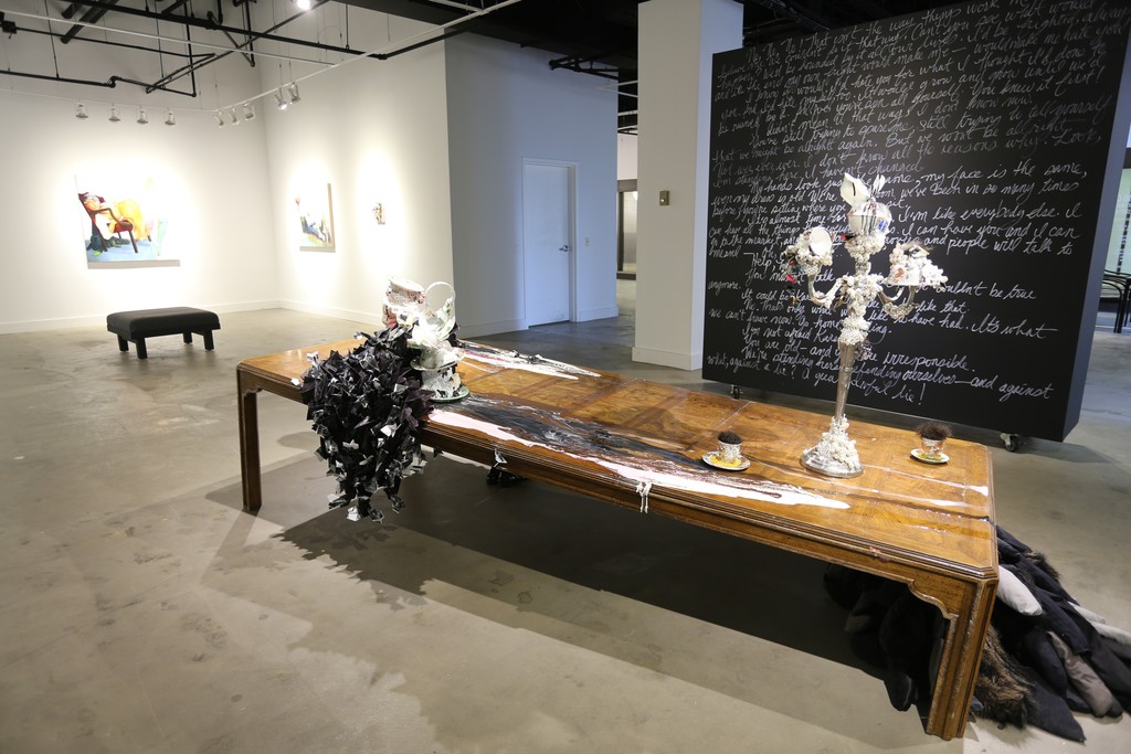 The black wall features text from the performance piece by David Antonio Cruz, greenhowiwantyou, green. Installation of a broken table with paint, paper with resin, sculpture and costumes pieces from past performances. The black wall features text from the performance piece by David Antonio Cruz, greenhowiwantyou, green. Installation of a broken table with paint, paper with resin, sculpture and costumes pieces from past performances.