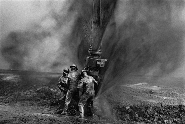 Sebastião Salgado, ‘Workers struggle to remove bolts from the remains of an old wellhead. Working with metal tools can produce sparks, threatening to consume everything in flames, Oil Wells, Greater Burhan, Kuwait’, 1991, Photography, Silver gelatin print, Galerie Bene Taschen